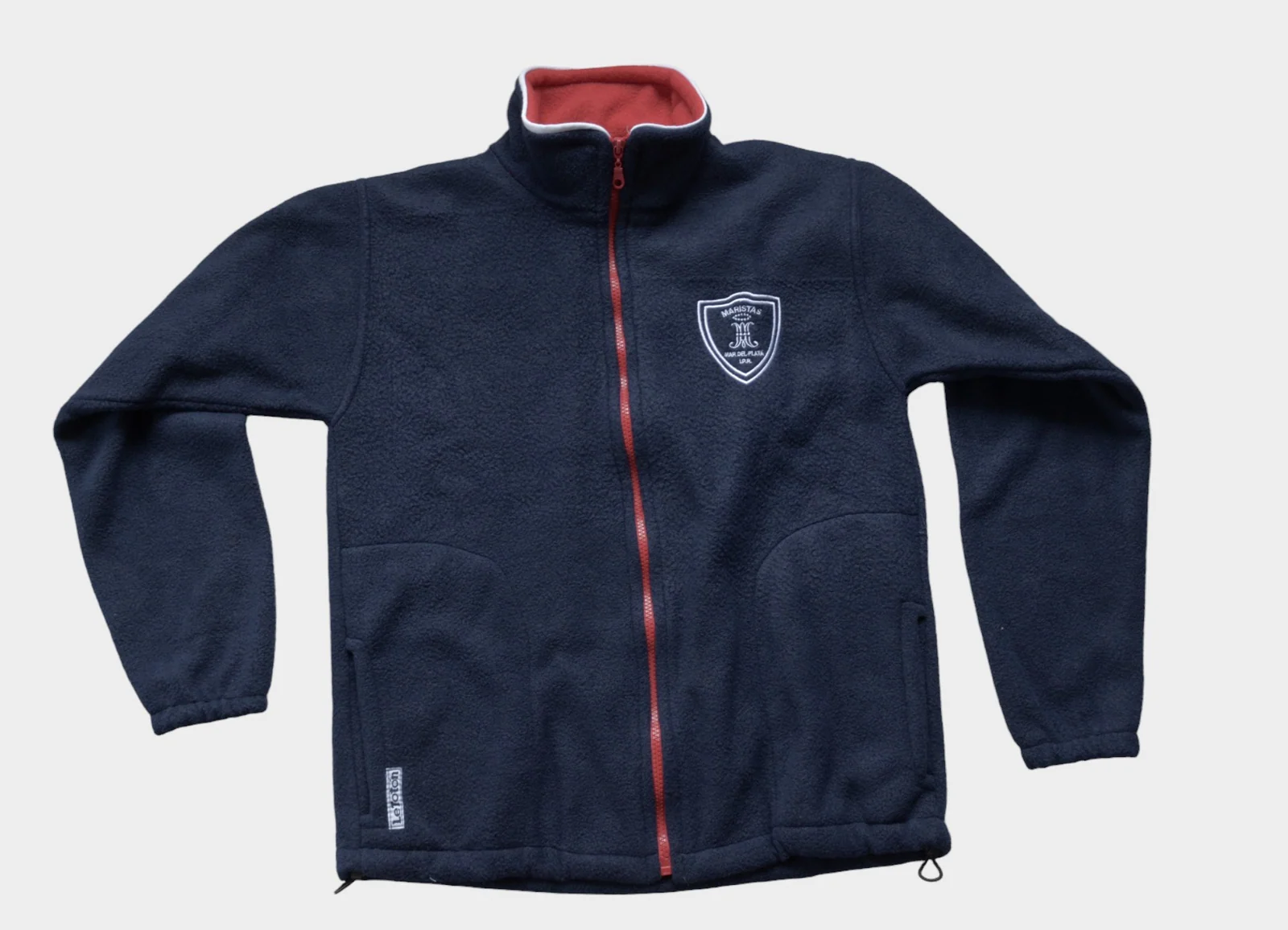 Campera polar azul marino de Peralta Ramos con cierre rojo